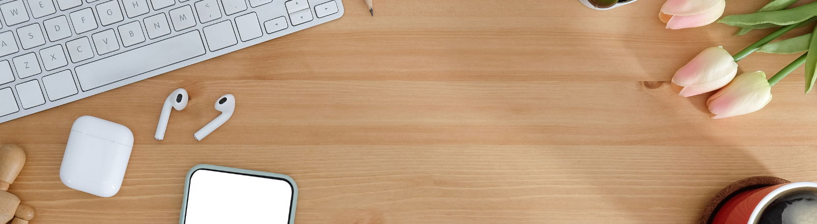 Top view of a wooden desk with a keyboard and mouse 